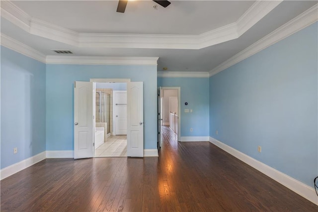 unfurnished bedroom featuring a raised ceiling, visible vents, ornamental molding, baseboards, and hardwood / wood-style flooring