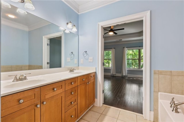 bathroom with tile patterned flooring, a sink, a bath, double vanity, and crown molding