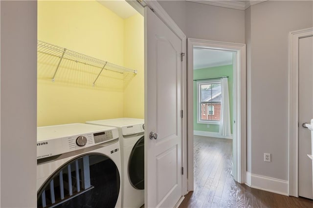 laundry room with ornamental molding, baseboards, dark wood finished floors, and washing machine and clothes dryer