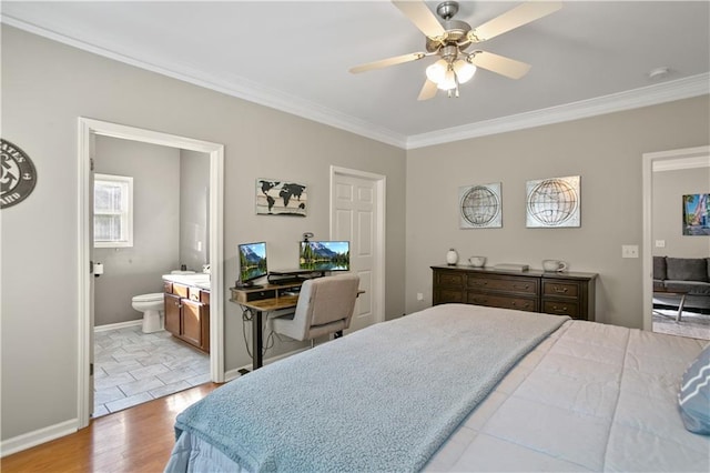 bedroom featuring baseboards, crown molding, light wood-style flooring, and ensuite bath