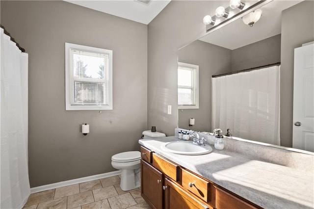 bathroom with toilet, vanity, baseboards, and visible vents