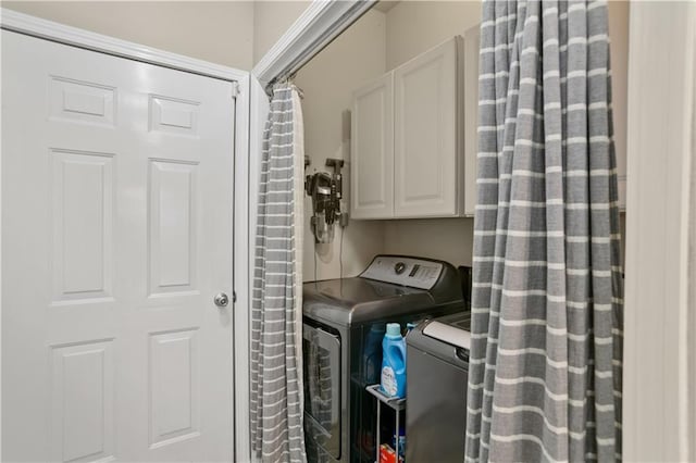 washroom with cabinet space and washing machine and dryer