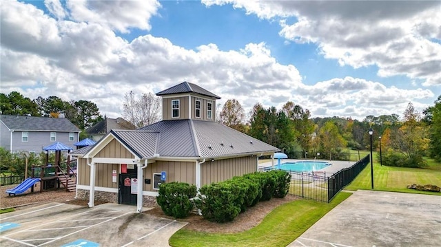 exterior space with a community pool and fence