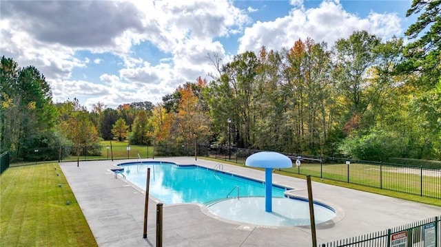 community pool featuring a patio area, fence, and a yard