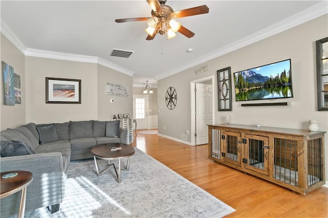 living room featuring crown molding, visible vents, light wood-type flooring, and ceiling fan with notable chandelier