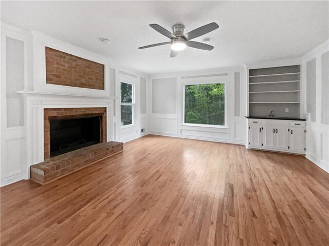 corridor featuring light hardwood / wood-style floors, ornamental molding, and sink