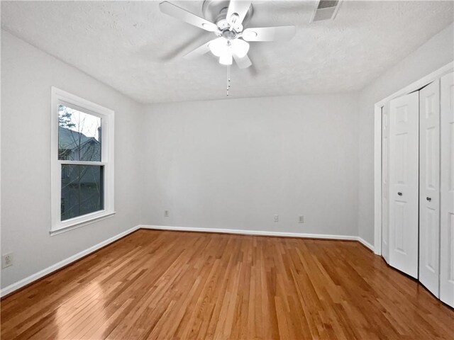 kitchen featuring white cabinets, light hardwood / wood-style floors, a kitchen island, and stainless steel appliances