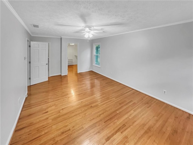 unfurnished bedroom featuring ceiling fan, a walk in closet, a textured ceiling, and light hardwood / wood-style flooring