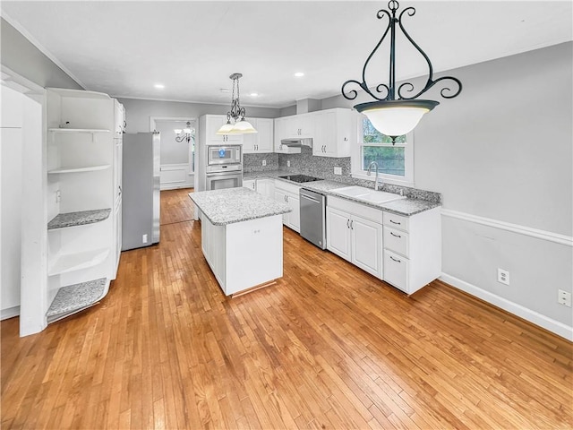 kitchen featuring white cabinets, a kitchen island, sink, and stainless steel appliances