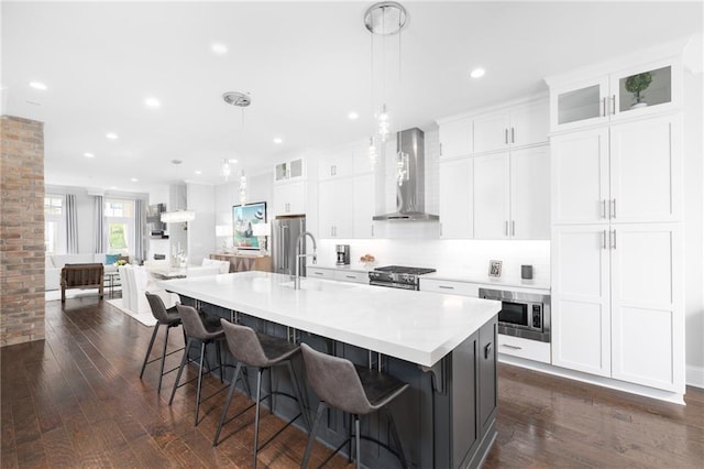 410 Concord St, Alpharetta, GA 30009 - kitchen with wall chimney range hood, appliances with stainless steel finishes, dark wood-style floors, a large island, and a sink