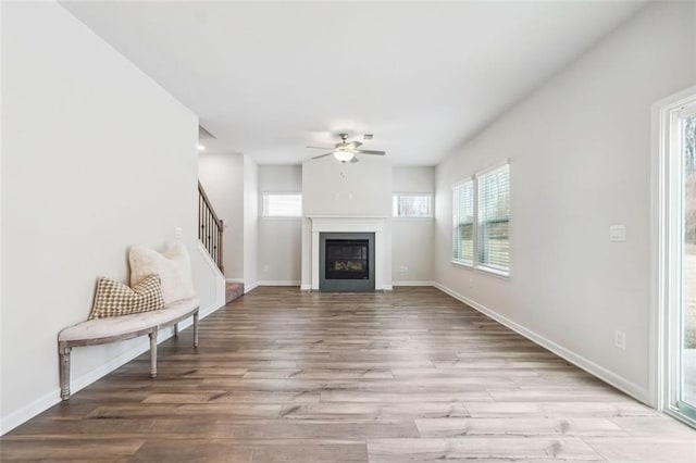 unfurnished living room featuring light hardwood / wood-style flooring and ceiling fan