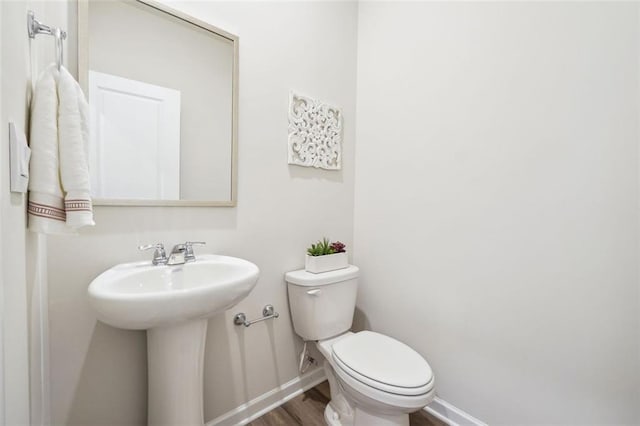 bathroom with hardwood / wood-style floors, toilet, and sink