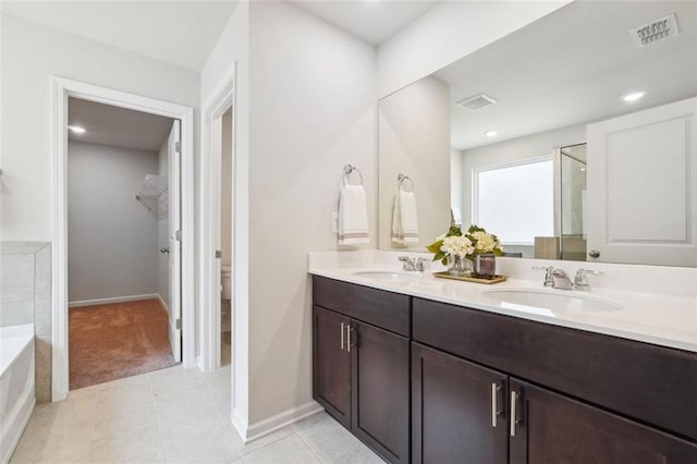 bathroom featuring shower with separate bathtub, vanity, and tile patterned floors