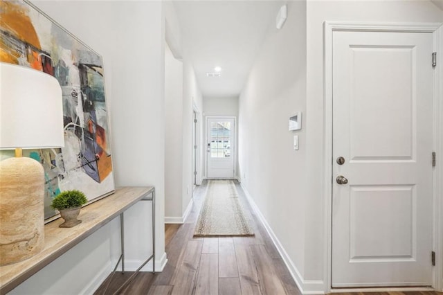 corridor with hardwood / wood-style flooring