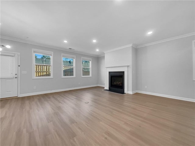 unfurnished living room featuring recessed lighting, wood finished floors, baseboards, and ornamental molding