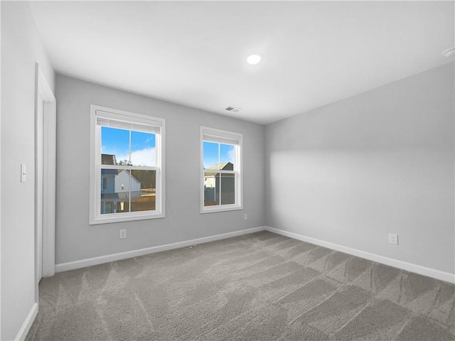 spare room featuring visible vents, baseboards, and carpet