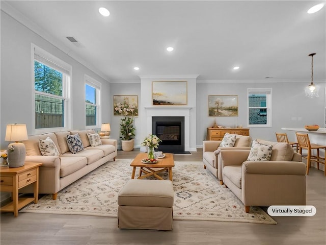 living room with crown molding, wood finished floors, and visible vents