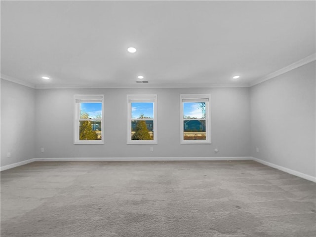 empty room with crown molding, a healthy amount of sunlight, and baseboards