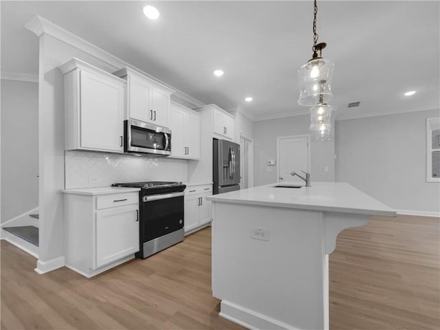 kitchen with a sink, appliances with stainless steel finishes, and ornamental molding