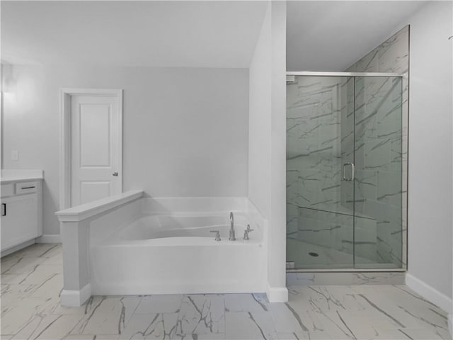 bathroom with a garden tub, marble finish floor, a stall shower, baseboards, and vanity