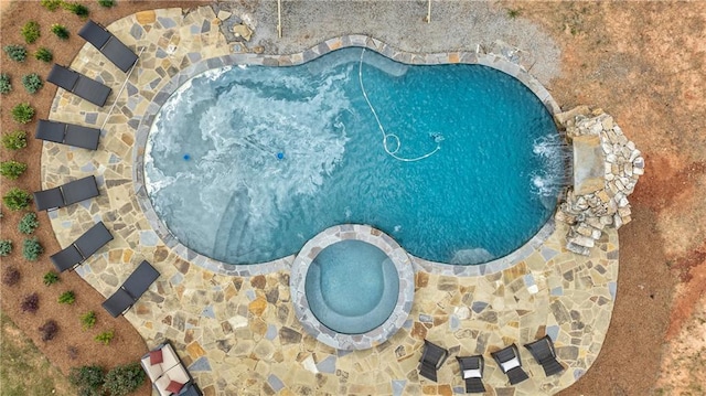 view of swimming pool featuring pool water feature and an in ground hot tub