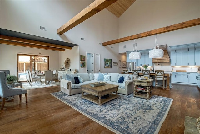 living room with dark wood-type flooring, a chandelier, and high vaulted ceiling