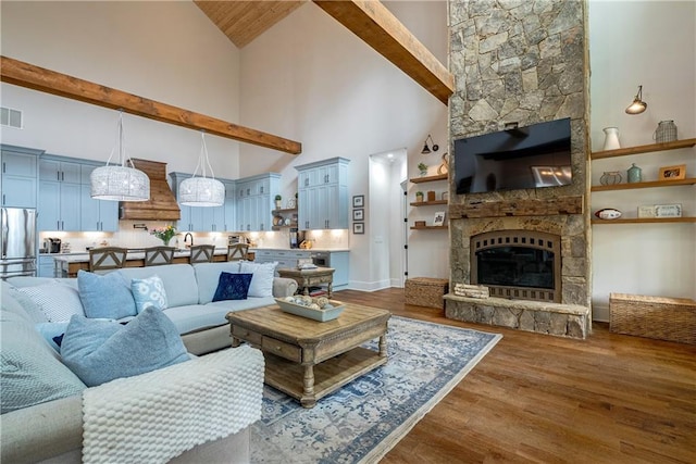 living room with a fireplace, wood-type flooring, beam ceiling, and high vaulted ceiling