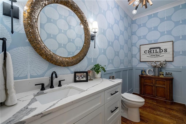 bathroom featuring hardwood / wood-style flooring, toilet, a notable chandelier, and vanity