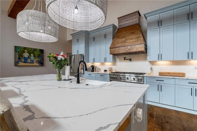 kitchen with decorative light fixtures, light stone counters, custom exhaust hood, and stainless steel appliances