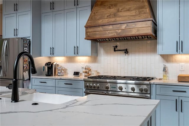 kitchen featuring light stone counters, premium range hood, decorative backsplash, and stainless steel appliances