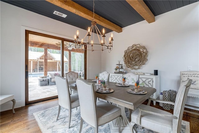 dining room with light hardwood / wood-style floors, beam ceiling, and a chandelier