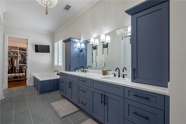 bathroom with a washtub, vanity, crown molding, and tile patterned flooring