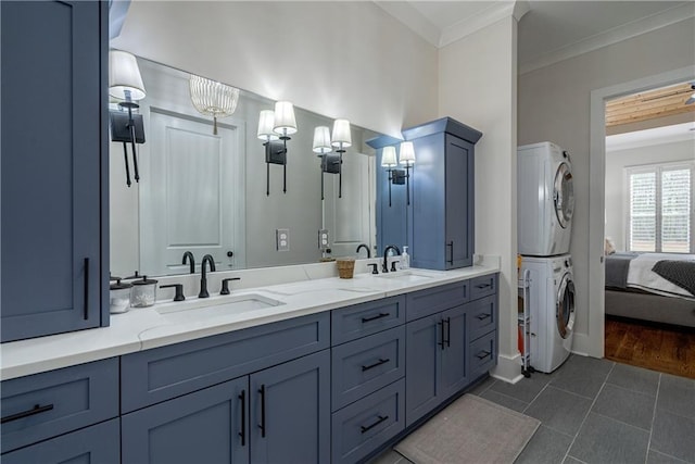 bathroom with vanity, tile patterned floors, stacked washer / dryer, and ornamental molding