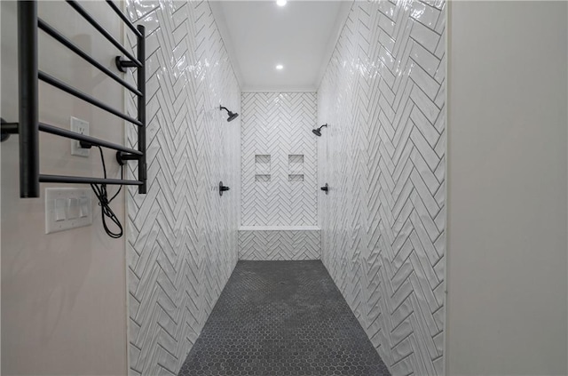 bathroom with a tile shower and tile walls