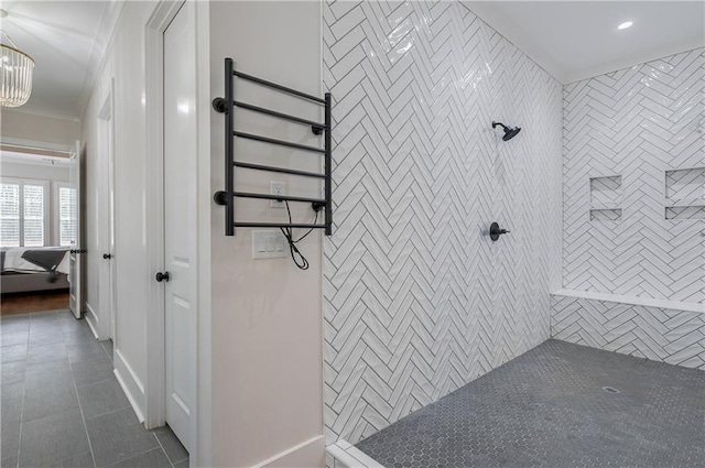 bathroom featuring a tile shower, tile patterned floors, and crown molding