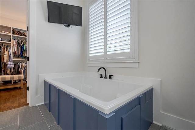 bathroom with a wealth of natural light and tile patterned flooring