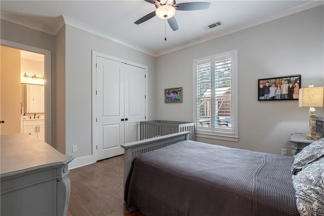 bedroom featuring a closet, ceiling fan, dark hardwood / wood-style flooring, ornamental molding, and connected bathroom