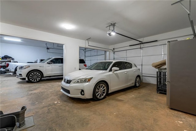 garage with a garage door opener and stainless steel fridge