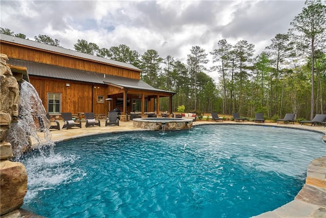 view of swimming pool with pool water feature, an in ground hot tub, and a patio area