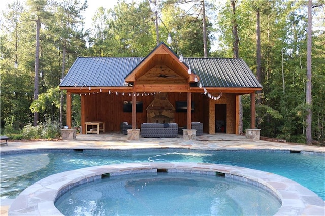 view of pool with an in ground hot tub, a patio, and an outdoor living space with a fireplace