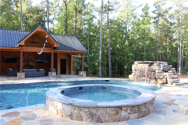 view of pool with an in ground hot tub, a patio area, an outdoor living space with a fireplace, and pool water feature