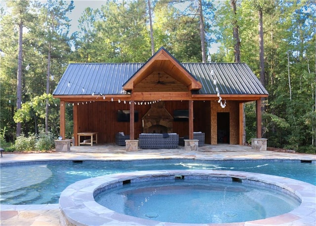 view of pool featuring an in ground hot tub, an outdoor living space with a fireplace, and a patio