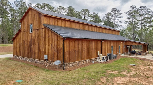 view of side of property with a patio area and a lawn