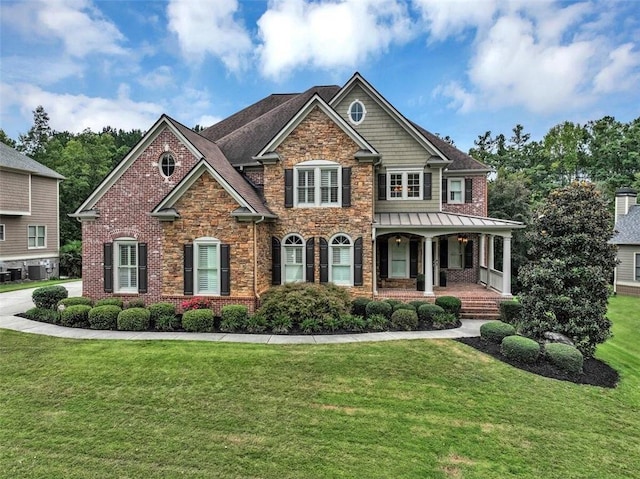 craftsman inspired home featuring central AC unit and a front lawn