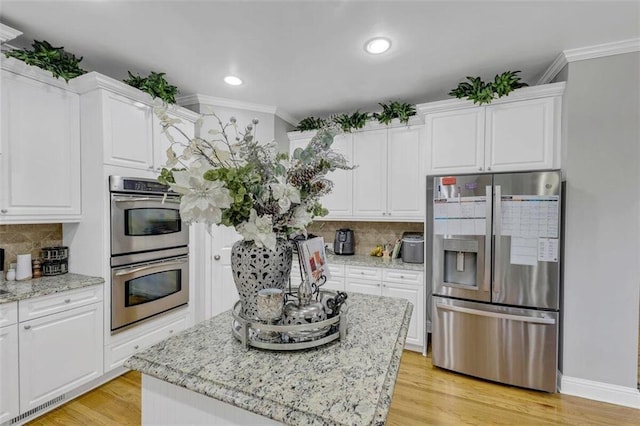 kitchen featuring stainless steel appliances, backsplash, and white cabinetry