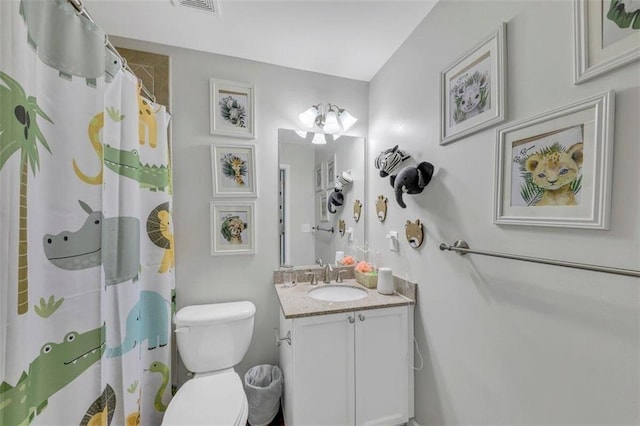 bathroom with large vanity and toilet