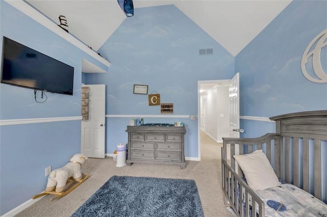 carpeted bedroom with high vaulted ceiling