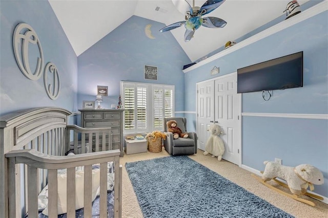 carpeted bedroom with ceiling fan, a closet, high vaulted ceiling, and a nursery area