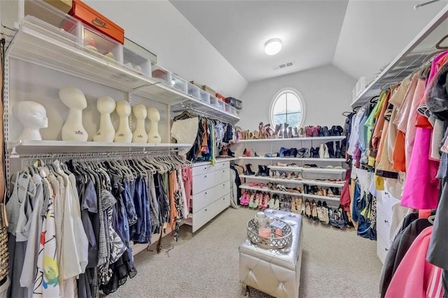 walk in closet with lofted ceiling and light carpet