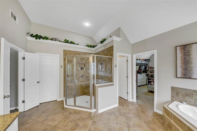 bathroom with tile floors, plus walk in shower, and vaulted ceiling